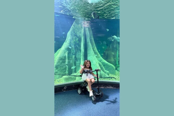 pequena-lo-encosta-em-pele-de-cobra-durante-visita-ao-maior-aquario-de-agua-doce-do-mundo